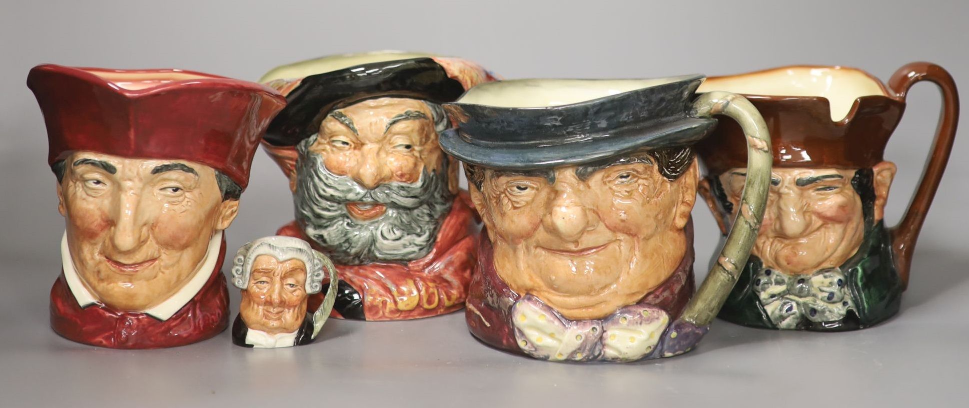 A group of four large Royal Doulton character jugs and one miniature character jug, including The Lawyer and Falstaff